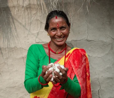 Bangladesh: Laily* with her son Safyun (2.5yr). Laily* works as a homebased garment worker. She joined garment factory at 12. Since 2019, she started working from home. Laily* brings orders from small factories and do them. Order like bed sheets, pillow covers, and one-piece dresses, these orders are given at home for sewing. With her income she hardly can earn 5000 taka. Photo: Fabeha Monir/Oxfam